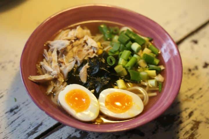 Helle Ramen-Schale mit gezupftem Hähnchen, Frühlingszwiebeln, Nori und einem halbierten weichen Ei