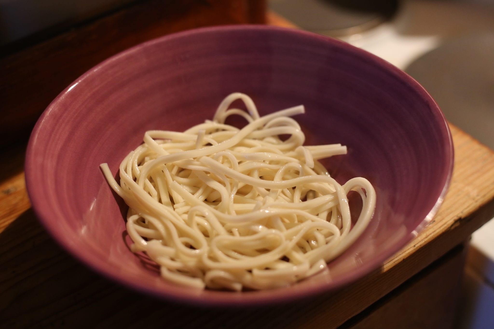 Selbst gemachter Nudelteig wird mit der Nudelmaschine zu Ramen-Nudeln ausgerollt und geschnitten