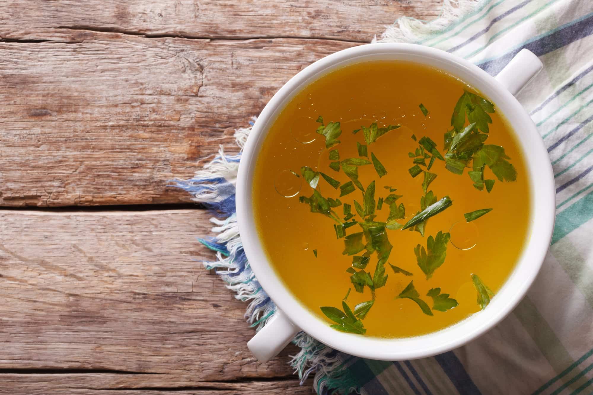 Köchelnde Ramen-Brühe mit Knochen und Aromaten im großen Topf